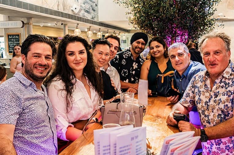 A crew cheering together on a rooftop bar