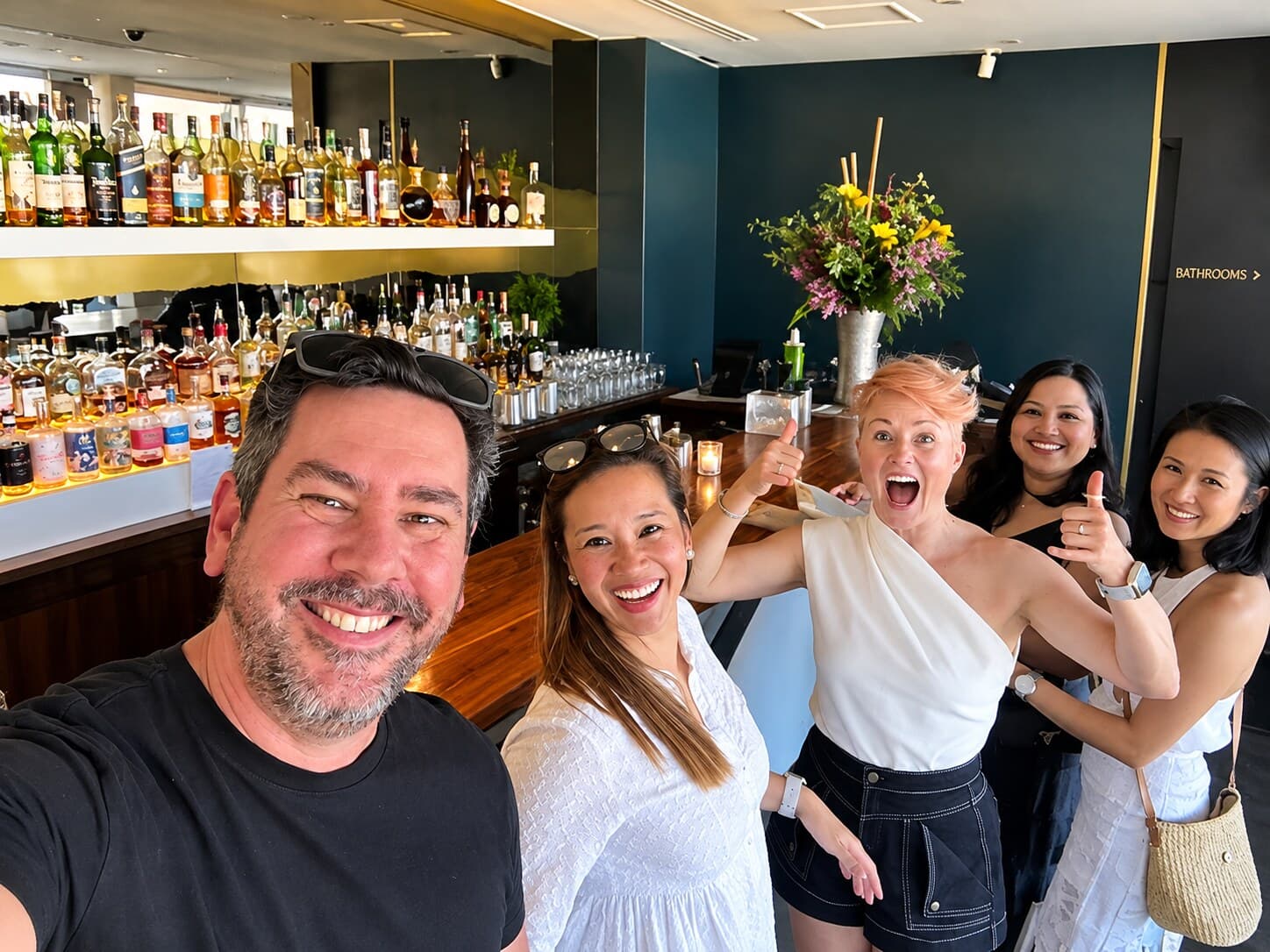 A group of friends smiling together at the bar during a CLASSIFIED night out